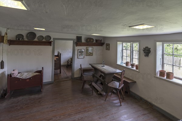Dining room with cradle in a historic farmhouse from the 19th century, Open-Air Museum of Folklore Schwerin-Muess, Mecklenburg-Western Pomerania, Germany, Europe