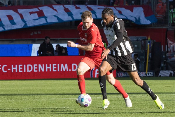 Football match, Nikola DOVEDAN 1.FC Heidenheim, left, in a duel for the ball with Jordan SIEBATCHEU Borussia Moenchengladbach, Voith-Arena football stadium, Heidenheim