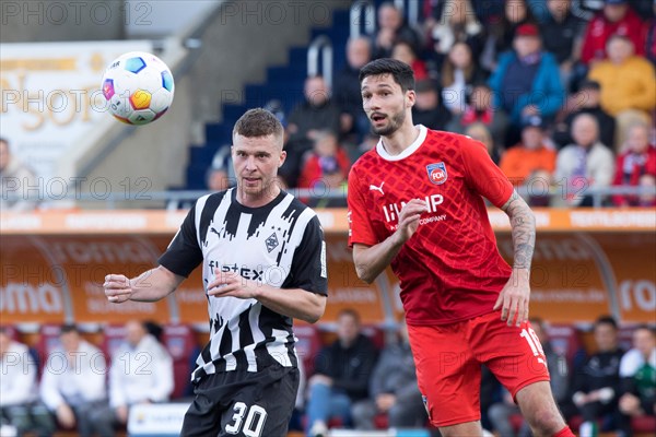 Football match, Tim KLEINDIENST 1.FC Heidenheim right and Nico ELVEDI Borussia Moenchengladbach with his eyes fixed on the ball, football stadium Voith-Arena, Heidenheim