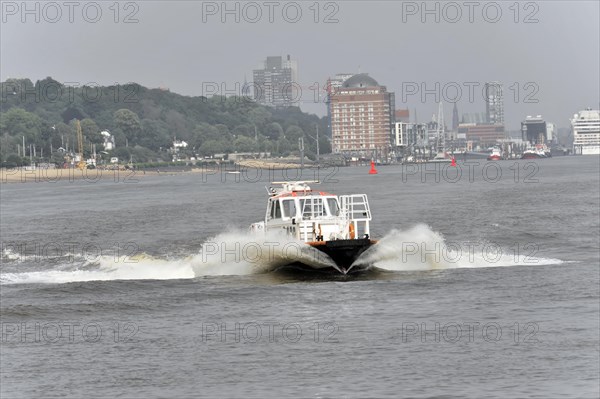 A speedboat cruises quickly through the harbour water and leaves waves in its wake, Hamburg, Hanseatic City of Hamburg, Germany, Europe