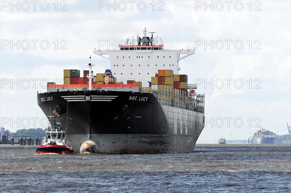 MSC LUCY, container ship with tug assistance on moving water in the harbour area, Hamburg, Hanseatic City of Hamburg, Germany, Europe