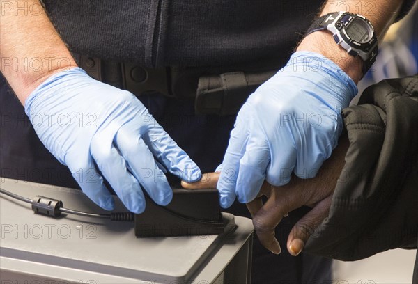 Refugees are registered and recorded by the Federal Police in Rosenheim. A Federal Police officer takes a fingerprint scan, 05/02/2016