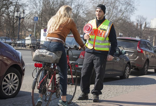 A Berlin police officer stops a cyclist during a traffic stop, 20/03/2018
