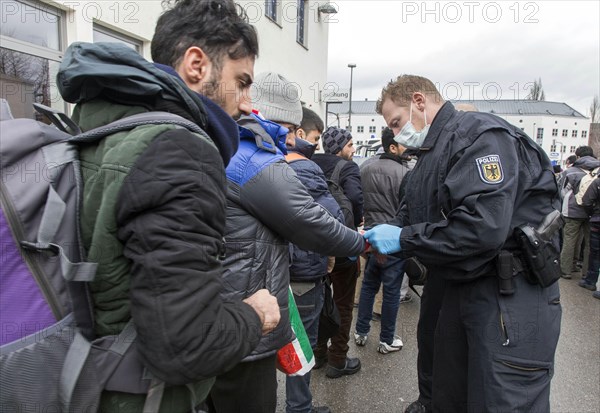 After arriving at Rosenheim station, refugees are given wristbands by federal police officers for identification and registration, 05/02/2016