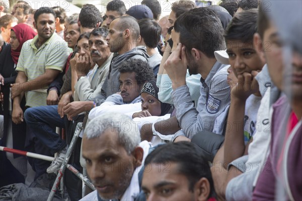 Refugees from Syria wait behind barriers in the central reception centre for asylum seekers at the State Office for Health and Social Affairs in Berlin, 26/08/2015