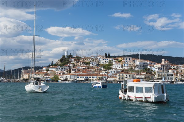 View over a busy harbour with boats and clear sky over a traditional coastal town, view from Galatas, Argolis, to Poros, Poros Island, Saronic Islands, Peloponnese, Greece, Europe