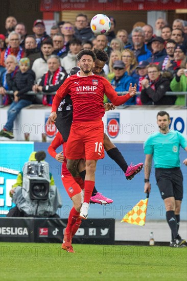 Football match, Kevin SESSA 1.FC Heidenheim in front in aerial combat for the ball with Nathan NGOUMOU Borussia Moenchengladbach, football stadium Voith-Arena, Heidenheim