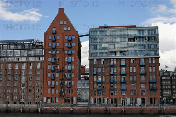 Architecturally diverse buildings on a riverbank (Elbe) with reflections in the water, Hamburg, Hanseatic City of Hamburg, Germany, Europe