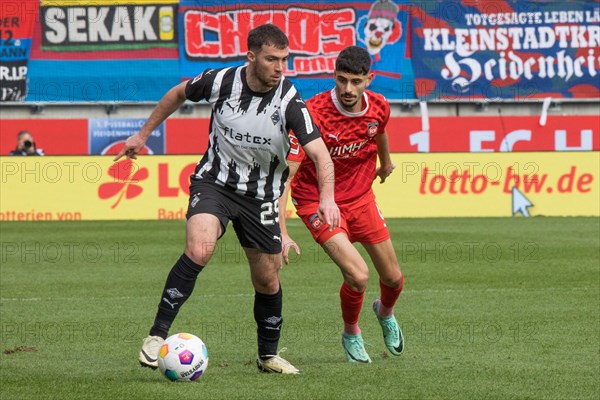 Football match, Eren DINKCI 1.FC Heidenheim right. in a duel for the ball with Joe SCALLY Borussia Moenchengladbach, football stadium Voith-Arena, Heidenheim