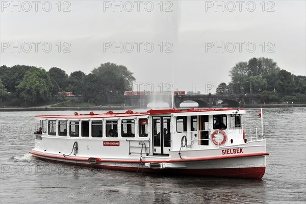 Passenger ship with red details sailing on a river under a grey sky, Hamburg, Hanseatic City of Hamburg, Germany, Europe