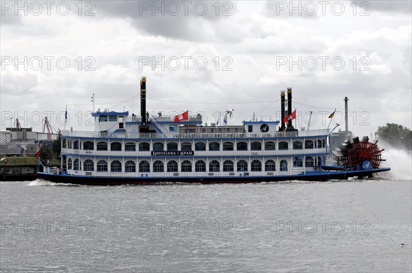 An antique paddle steamer named 'Louisiana Star' sailing on the water against a cloudy sky, Hamburg, Hanseatic City of Hamburg, Germany, Europe