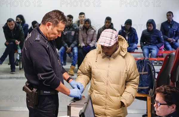 Refugees are registered and recorded by the Federal Police in Rosenheim. A Federal Police officer takes a fingerprint scan, 05/02/2016