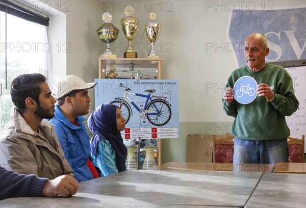 Syrian refugees learn traffic rules during an integration course. An employee of the Oberspreewald-Lausitz district and traffic watch organisation shows and explains traffic signs and rules to the refugees in the rooms of the Grossraeschen sports club, 05/10/2016