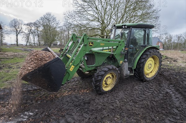 Tractor loading woodchippings on a farm, Othenstorf, Mecklenburg-Vorpommern, Germany, Europe