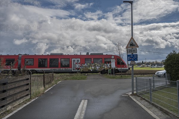 Suburban railway crossing an ungated level crossing in a village, Forth, Middle Franconia, Bavaria, Germany, Europe