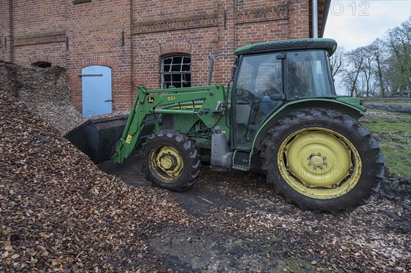 Tractor loading woodchippings on a farm, Othenstorf, Mecklenburg-Vorpommern, Germany, Europe