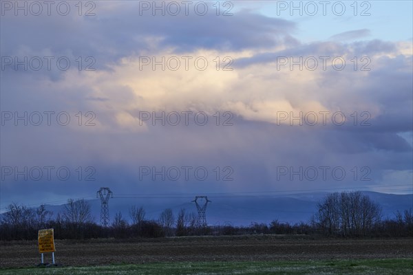 Weather change with mighty light to grey-blue clouds illuminated by the evening sun over the Black Forest as seen from Algolsheim, Haut-Rhin, Grand Est, France, Europe