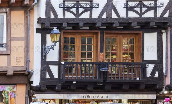 Balcony and window on a half-timbered house and the shop La Belle Alsace in the old town centre of Colmar, Department Haut-Rhin, Grand Est, France, Europe