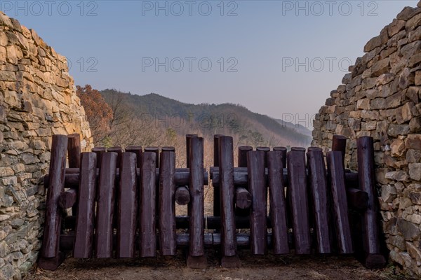 Closeup of wooden log blockade at gate of mountain fortress made of flat stones in Boeun, South Korea, Asia