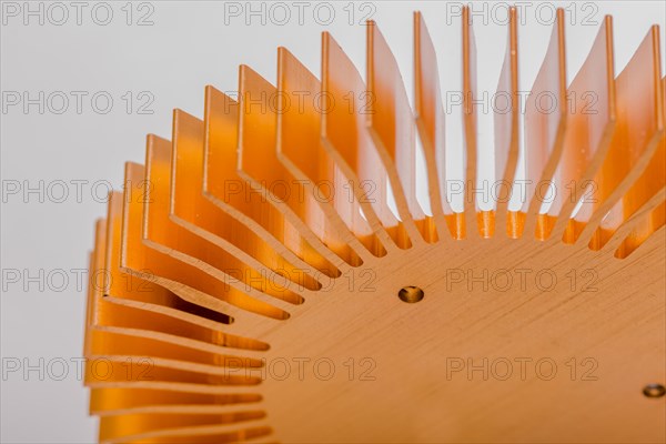 Closeup of fins and mounting surface on round copper computer heat sink on white background