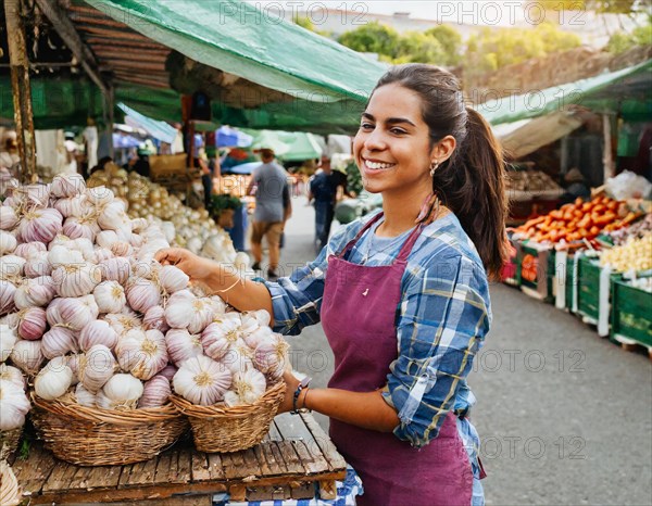 Food, spices, garlic, Allium sativum, many bulbs on a market stall, woman as saleswoman in Italy, AI generated, AI generated