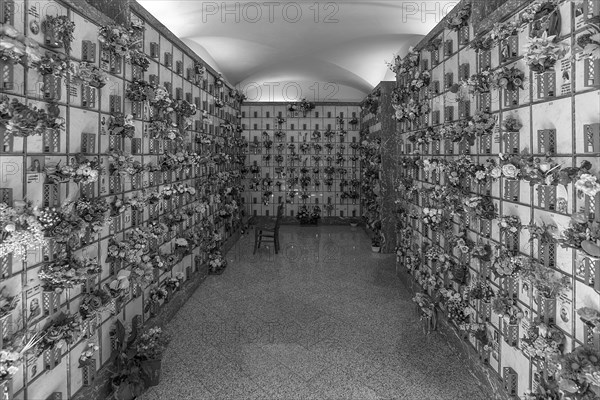 Graves with floral decorations in a hall at the Monumental Cemetery, Cimitero monumentale di Staglieno), Genoa, Italy, Europe