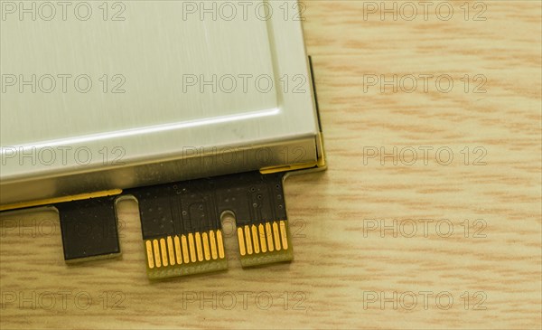 A dongle device with gold contacts lying next to a beige surface, in South Korea