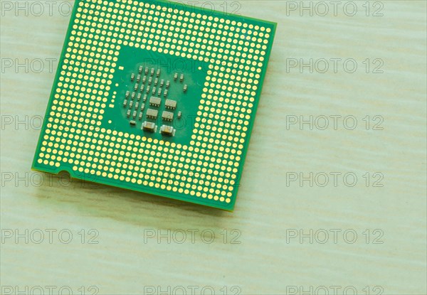 Bottom side of central processor unit (CPU) on blurred wood grain table top