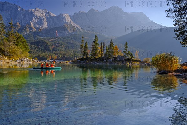 Canoeists on a mountain lake in front of steep mountains, reflection, evening light, autumn, Eibsee lake, view of Zugspitze, Bavaria, Germany, Europe