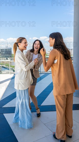 Three radiant women share a moment of joy, their laughter and smiles illuminaties the scene