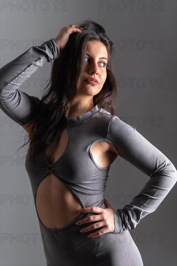 Studio photo with grey background of a beauty female model looking away with sensual pose