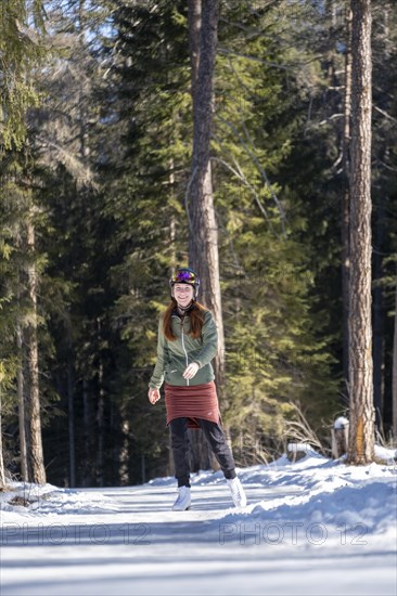 Ice skater, ice path through the forest, Sur En, Sent near Scuol, Engadin, Switzerland, Europe