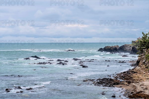 Rough waves hit a rocky coastline under an overcast sky, in Ulsan, South Korea, Asia