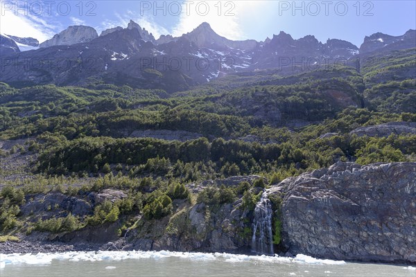 Waterfall, floating ice, mountain range, Andes, Lago Grey, Torres del Paine National Park, Parque Nacional Torres del Paine, Cordillera del Paine, Towers of the Blue Sky, Region de Magallanes y de la Antartica Chilena, Ultima Esperanza Province, UNESCO Biosphere Reserve, Patagonia, End of the World, Chile, South America