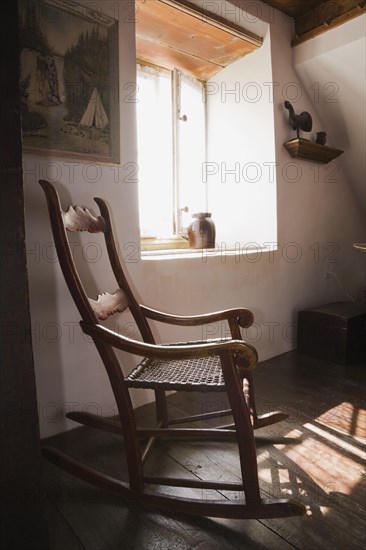 Antique wooden rocking chair in master bedroom on upstairs floor inside old 1785 home, Quebec, Canada, North America