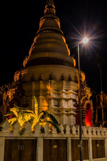 A temple's warm tones are highlighted by a spotlight against the night sky, in Chiang Mai, Thailand, Asia