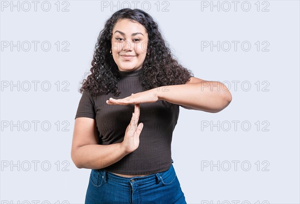Smiling woman showing time out gesture isolated. Young woman making time out gesture with palms isolated