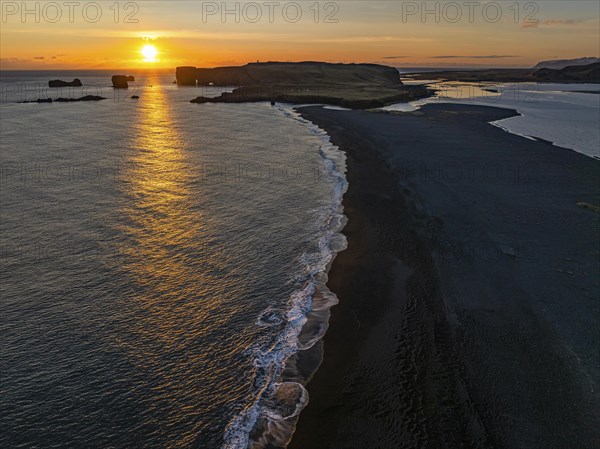 Sunset over the rocks of Dyrholaey, drone shot, Sudurland, Iceland, Europe