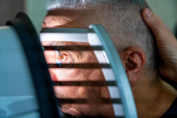 Close-up photo of a senior man receiving a laser treatment for glaucoma in a clinic