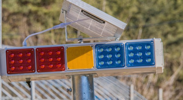 Traffic lights with LED panels in red, amber, and blue mounted on a pole, in South Korea