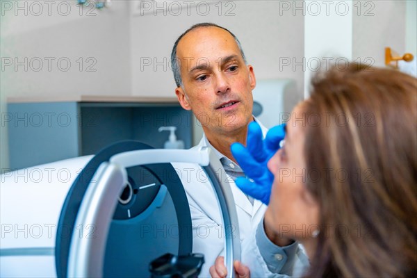 Ophthalmologist checking the eye of a woman during treatment for glaucoma using innovative laser machine