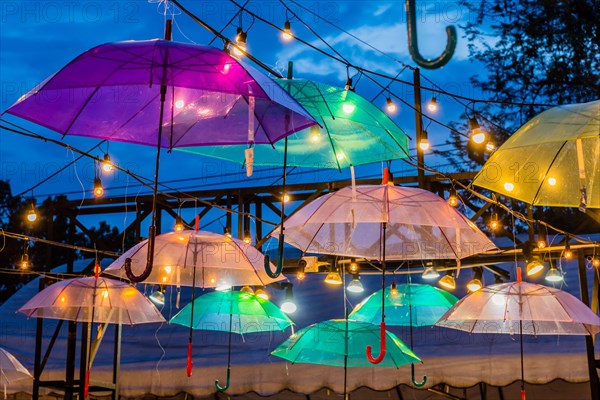 Colorful umbrellas with lights hang artistically against a dusk sky, in Chiang Mai, Thailand, Asia
