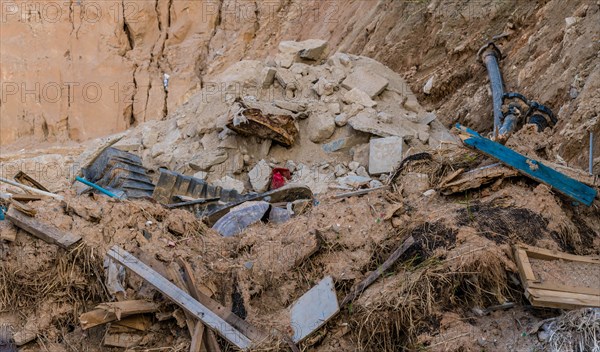 Construction waste with pipes and bricks on disturbed soil, in South Korea