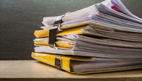 Folders with yellow tabs are piled up untidily on a table, symbolising bureaucracy, AI generated, AI generated