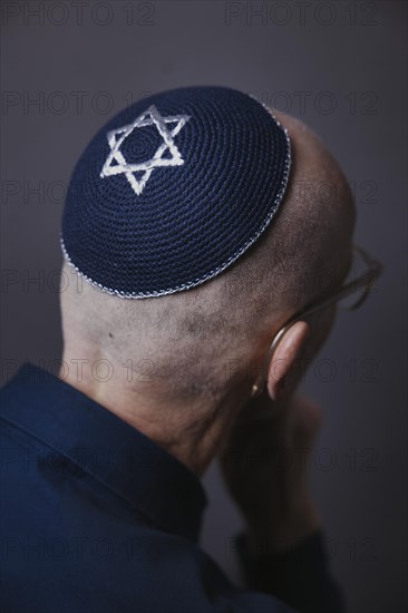 Jewish man wearing a kippa with a Star of David on his head, back view, studio shot, Germany, Europe