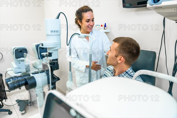 Female optometrist talking with male patient in the clinic
