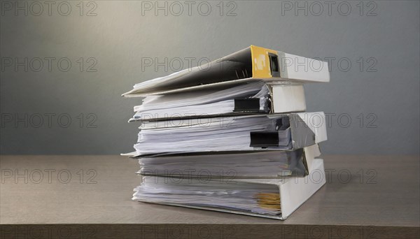 A pile of folders with lots of papers against a grey background, symbolism bureaucracy, AI generated, AI generated