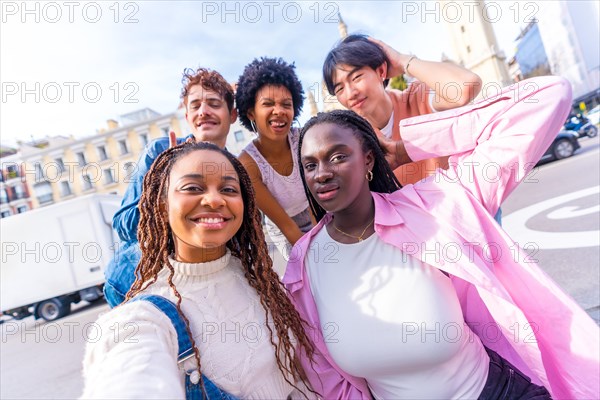 Multiracial friends taking a selfie together while visiting a city in a sunny day