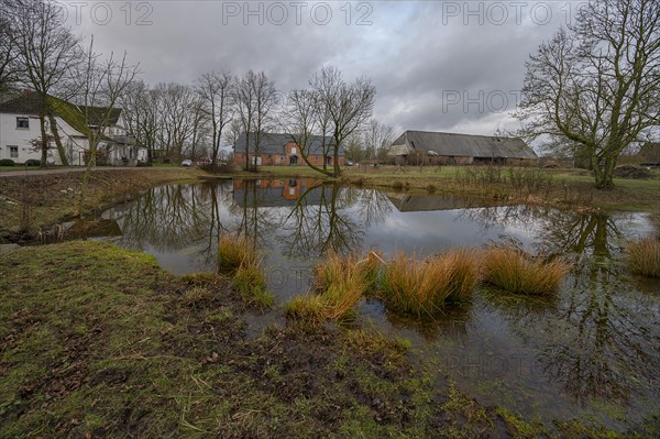 Manor house, horse stable and barn from 1920, in front the extinguishing pond, in cloudy weather, Othenstorf, Mecklenburg-Vorpommern, Germany, Europe