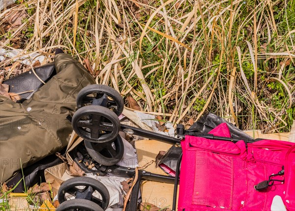 Discarded luggage and a baby stroller among debris on grass, in South Korea